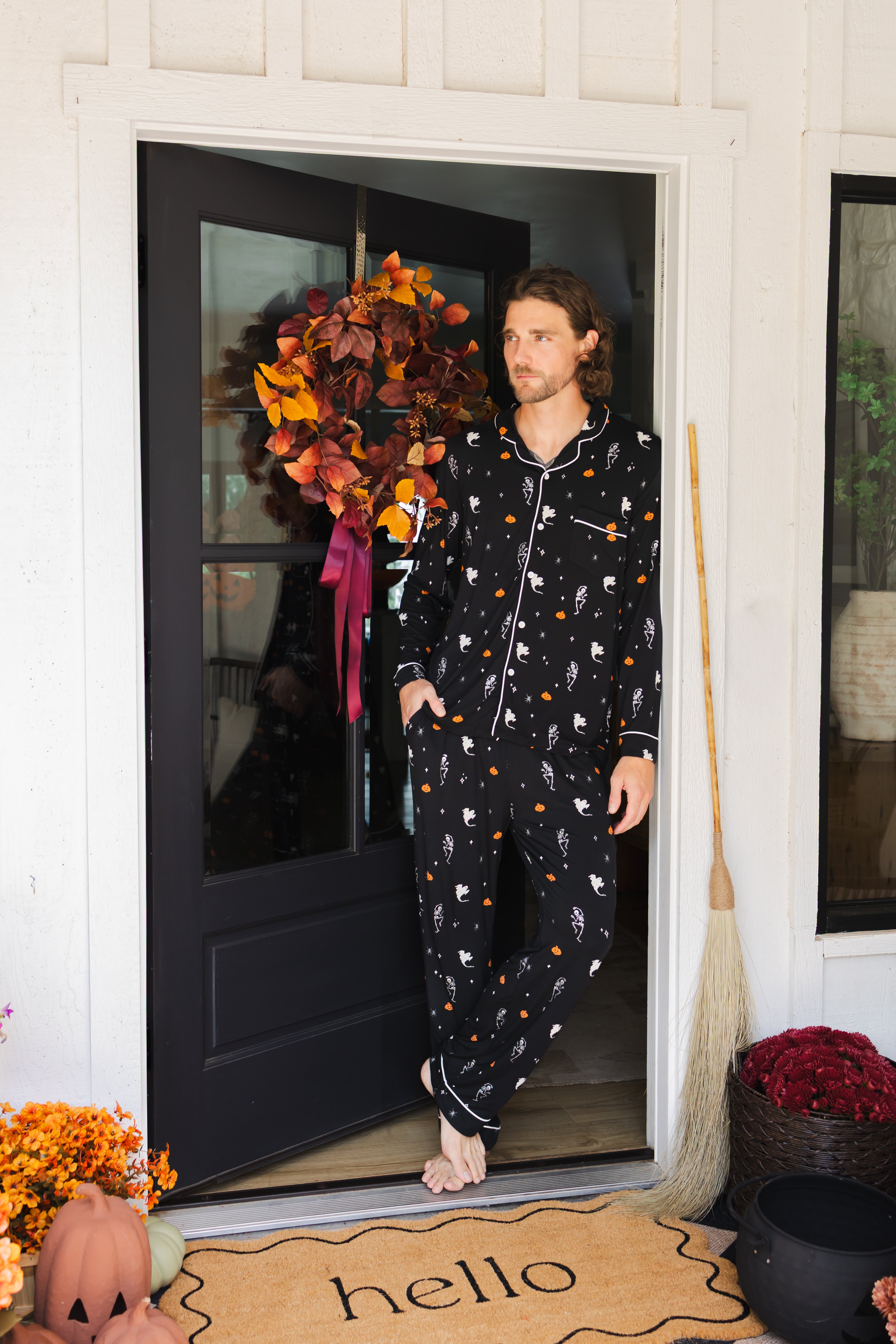 Model posing in Men's Long Sleeve Pajama Set in Halloween Friends print standing in doorway  ::: Model is 6'2" wearing size L ///