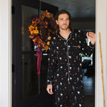 Model wearing Men's Long Sleeve Pajama Set in Halloween Friends print standing in doorway 