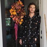 Model smiling in doorway wearing Men's Long Sleeve Pajama Set in Halloween Friends print ::: Model is 6'2" wearing size L ///