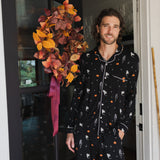 Model smiling in doorway wearing Men's Long Sleeve Pajama Set in Halloween Friends print ::: Model is 6'2" wearing size L ///