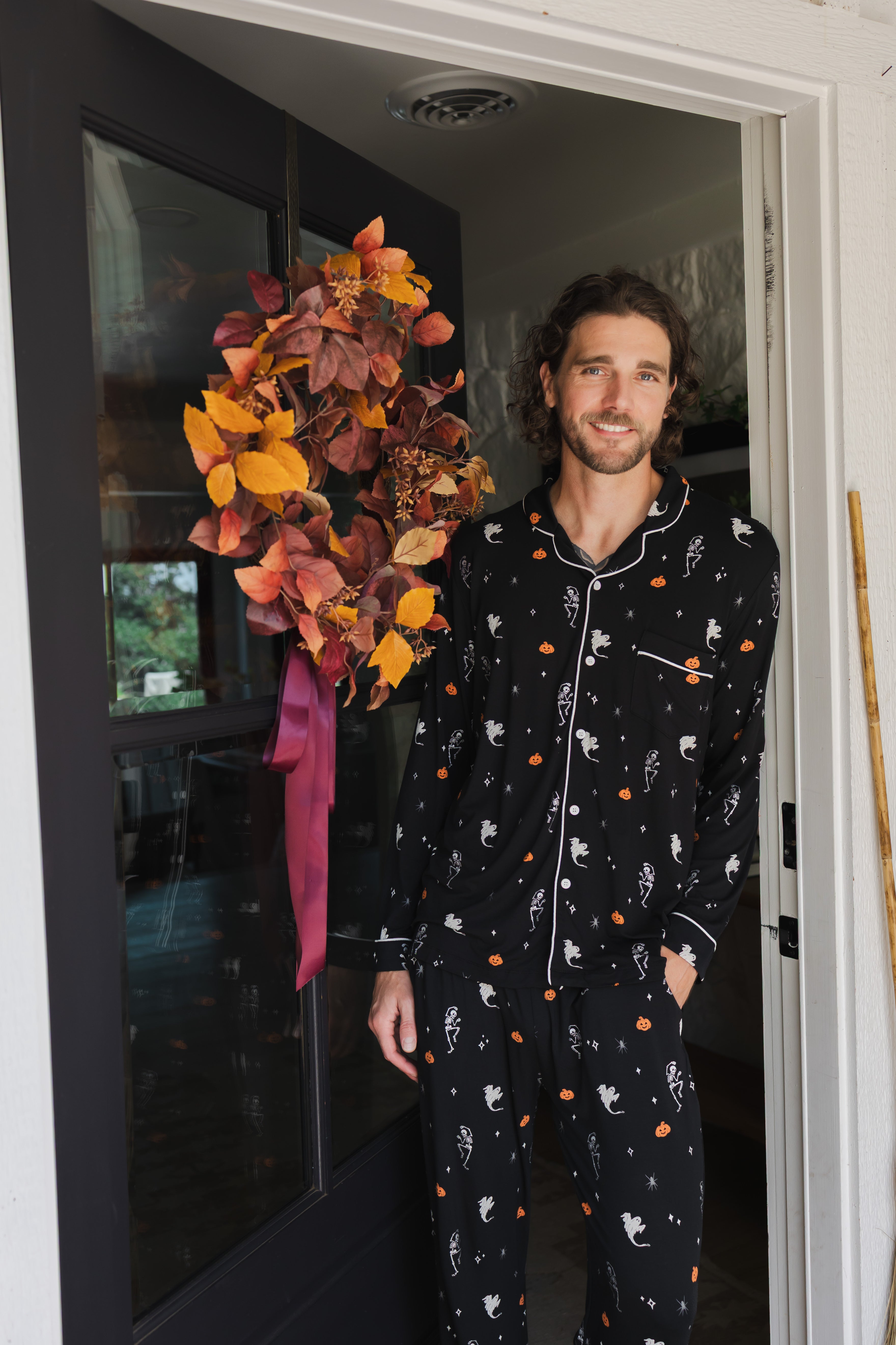 Model smiling in doorway wearing Men's Long Sleeve Pajama Set in Halloween Friends print ::: Model is 6'2" wearing size L ///