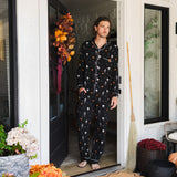 Model wearing Men's Long Sleeve Pajama Set in Halloween Friends print standing in doorway 