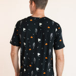 Back side of Modal wearing Men's Crew Neck Tee in Halloween Friends print over blue jeans on a beige background