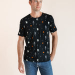 Modal posing in Men's Crew Neck Tee in Halloween Friends print over blue jeans on a beige background
