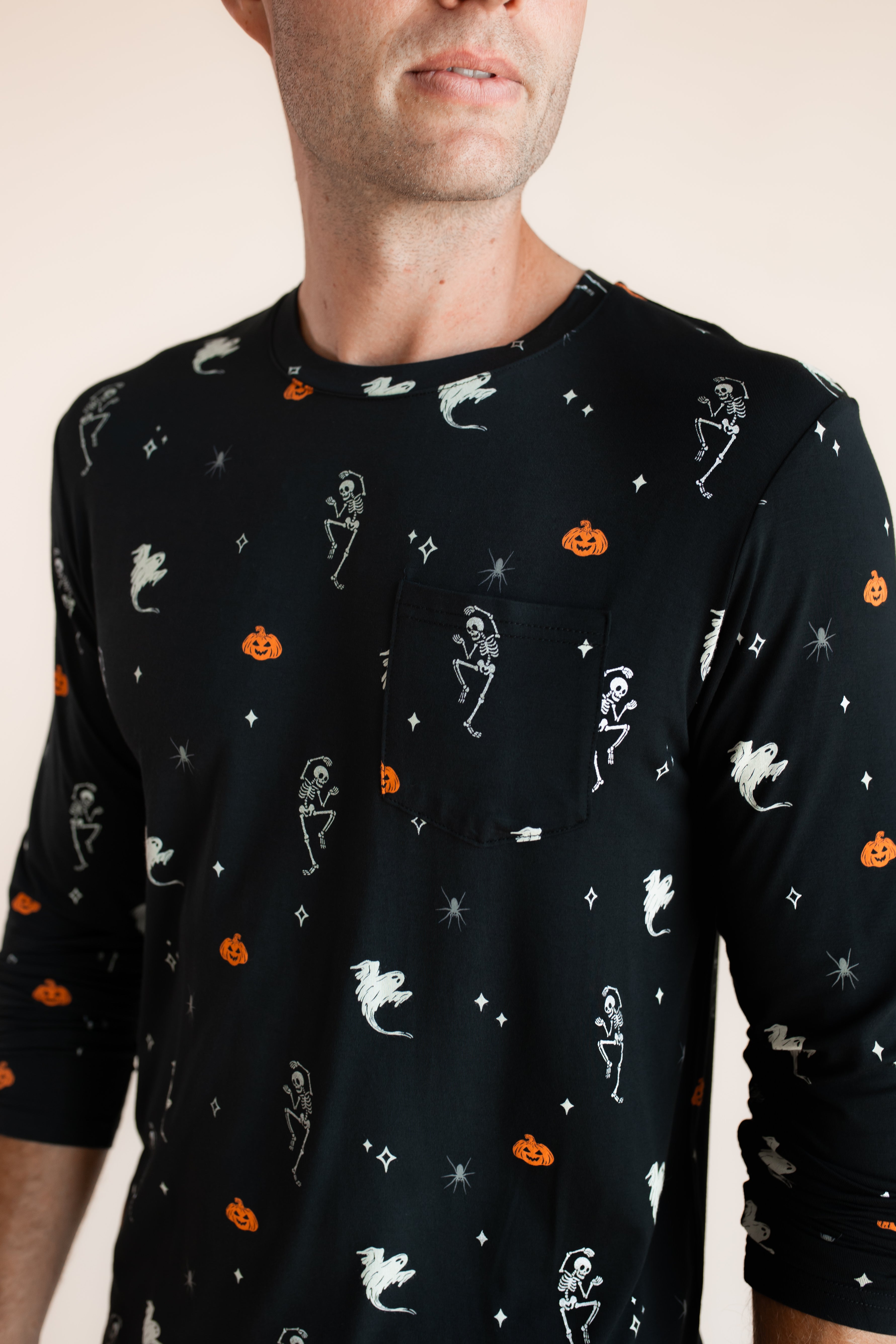Close up of Modal wearing Men's Jogger Set in Halloween Friends print on beige background