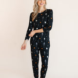 Modal posing in Women's Jogger Pajama Set in Halloween Friends print on a beige background