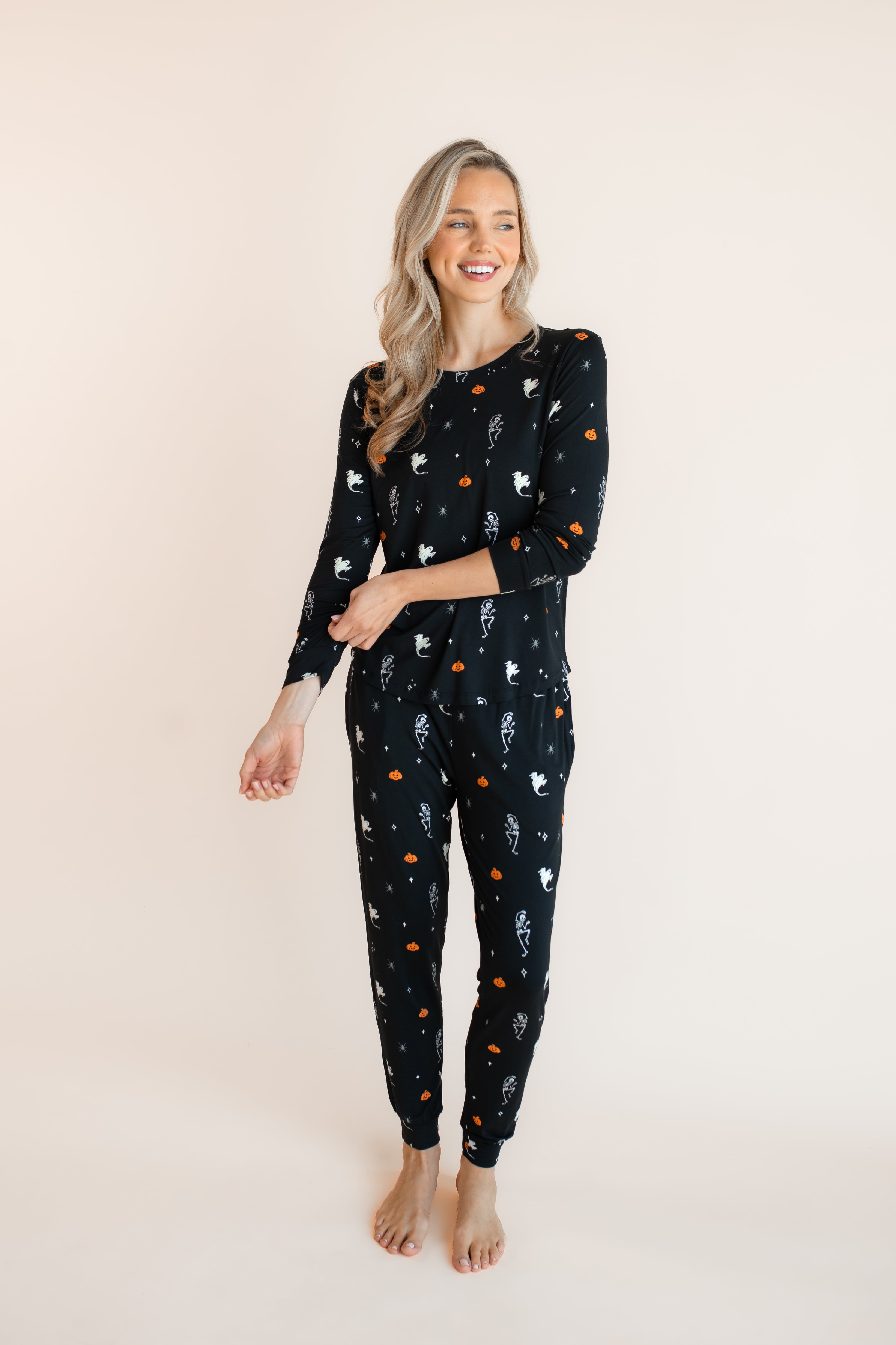 Modal posing in Women's Jogger Pajama Set in Halloween Friends print on a beige background