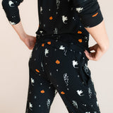 Back side of Modal wearing Women's Jogger Pajama Set in Halloween Friends print on a beige background