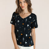 Modal wearing Women's Oversized V-Neck Tee in Halloween Friends print over white pants on a beige background ::: Model is 5'9.5" wearing size XS ///