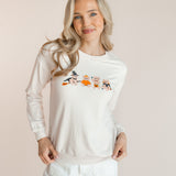 Modal posing in off white Women's Sweatshirt with Halloween Teddy print in the center over white pants standing in front of a beige background ::: Model is 5'9" wearing size XS ///