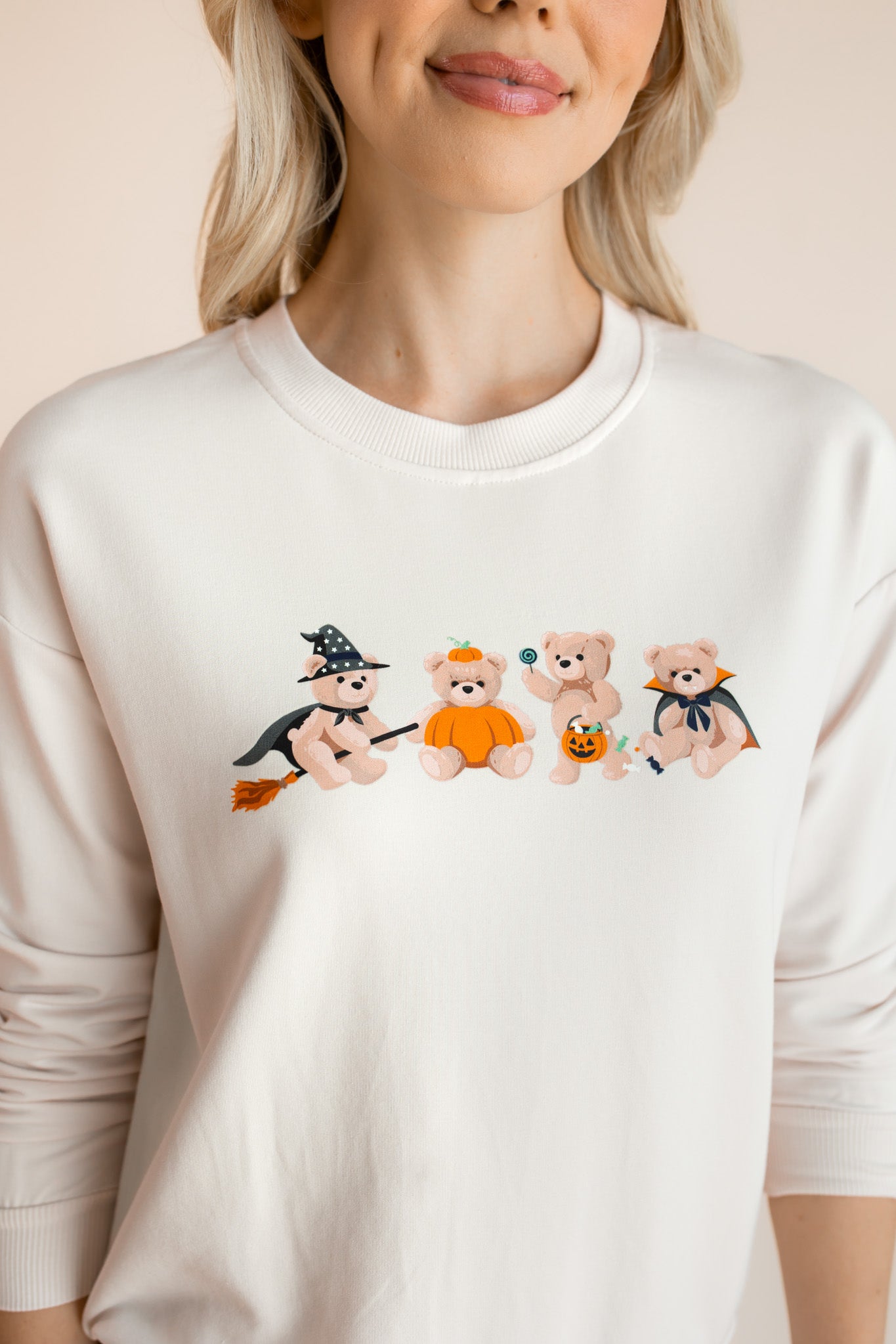 Close up of Modal wearing off white Women's Sweatshirt with Halloween Teddy print in the center