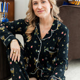 Woman wearing black long sleeve pajama set printed with Hanukkah elements 