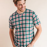 Man looking over his shoulder laughing with his hands in jean pockets wearing a crew neck tee in holiday plaid.
::: Model is 6'3" wearing size L ///