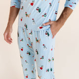 Man showcasing the pockets on Men's Jogger Set in Holiday Pups print on a beige background
