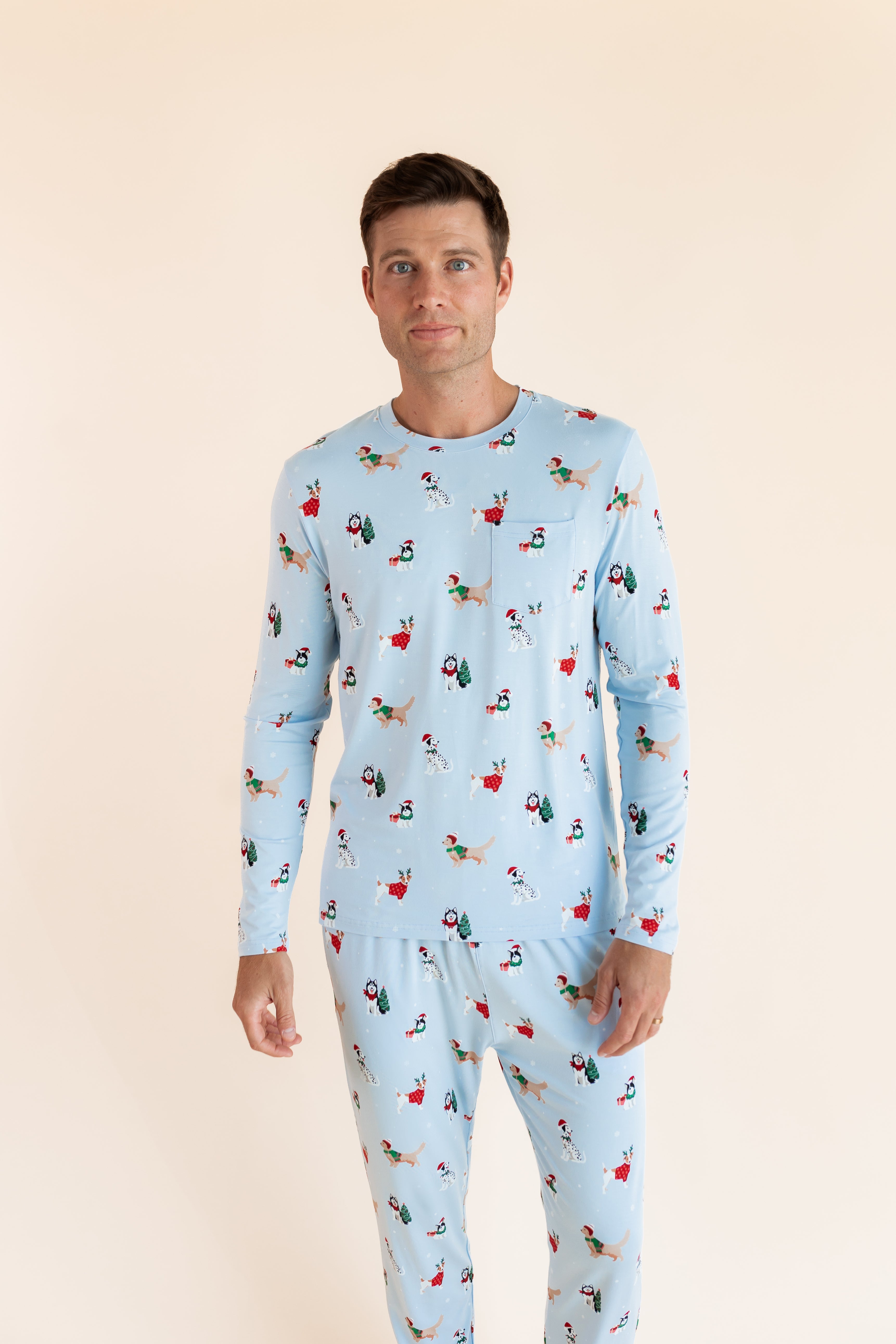 Man wearing Men's Jogger Set in Holiday Pups print on a beige background