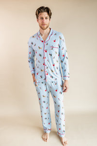 Man posing in Men's Long Sleeve Pajama Set in Holiday Pups print on a beige background