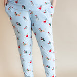 Woman showcasing the pockets on Women's Jogger Pajama Set in Holiday Pups print on a beige background