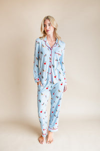 Woman wearing Long-Sleeved Women's Pajama Set in Holiday Pups print on a beige background