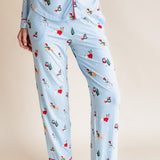 Woman showcasing the front side of Long-Sleeved Women's Pajama Set in Holiday Pups print on a beige background
---1605 3