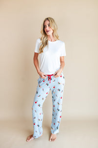 Woman wearing Women's Lounge Pants in Holiday Pups print under white T-shirt on a beige background