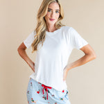 Woman posing in Women's Lounge Pants in Holiday Pups print under white T-shirt on a beige background