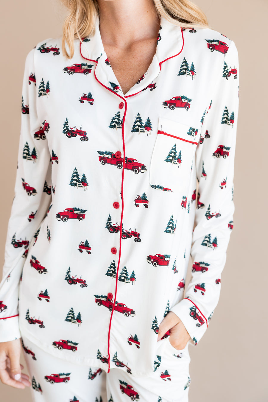 top part of a woman with her hand in her pant pocket wearing long sleeve pajama set in holiday tree farm