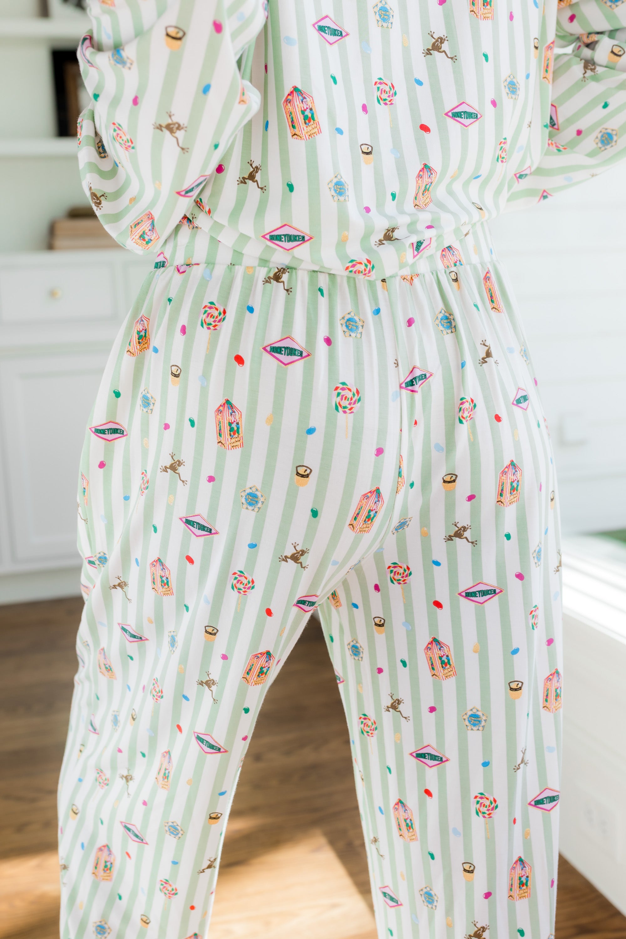 Back side of Long-Sleeved Women's Pajama Set pajamas with colorful Harry Potter patterns on a green and white striped fabric