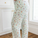Side view of a green and white striped Women's lounge pants with colorful Harry Potter patterns with pockets