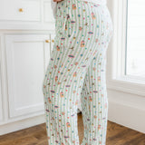 Side view of a green and white striped Women's lounge pants with colorful Harry Potter patterns with pockets
