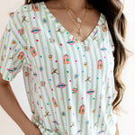 Model wearing Women's Relaxed Fit V-Neck having colorful Harry Potter patterns on a green and white striped fabric on a beige background

::: Model is 5'3" wearing size S ///


