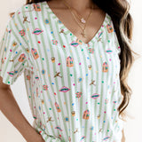 Model wearing Women's Relaxed Fit V-Neck having colorful Harry Potter patterns on a green and white striped fabric on a beige background

::: Model is 5'3" wearing size S ///


