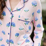 Woman outside with her hand in her pocket wearing a long sleeve pajama top in Hydrangea Sakura print. ---PJ 2