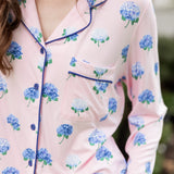 Woman outside with her hand in her pocket wearing a long sleeve pajama top in Hydrangea Sakura print. ---PJ 2