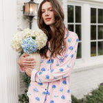 Woman outside holding a vase of hydrangeas in long sleeve pajamas in Hydrangea Sakura print.
 ---PJ 4
