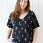 Model smiling while wearing the Women's V-Neck in Skeleton paired with light jeans