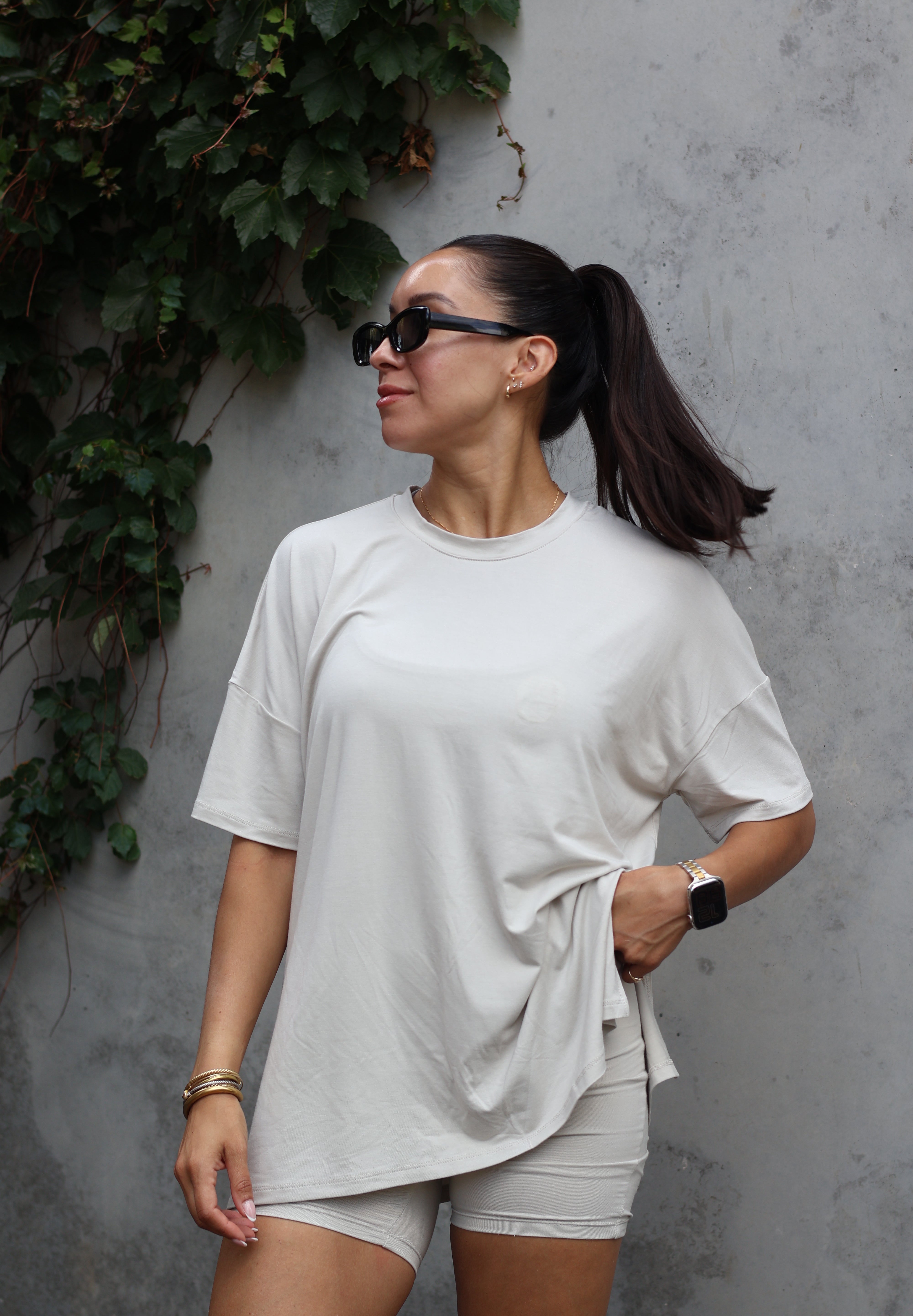 Woman modeling oat biker short set accessorized with sunglasses and jewelry 