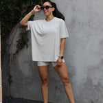 Woman modeling Women’s Biker Short Set in Oat accessorized with sunglasses and jewelry and sneakers