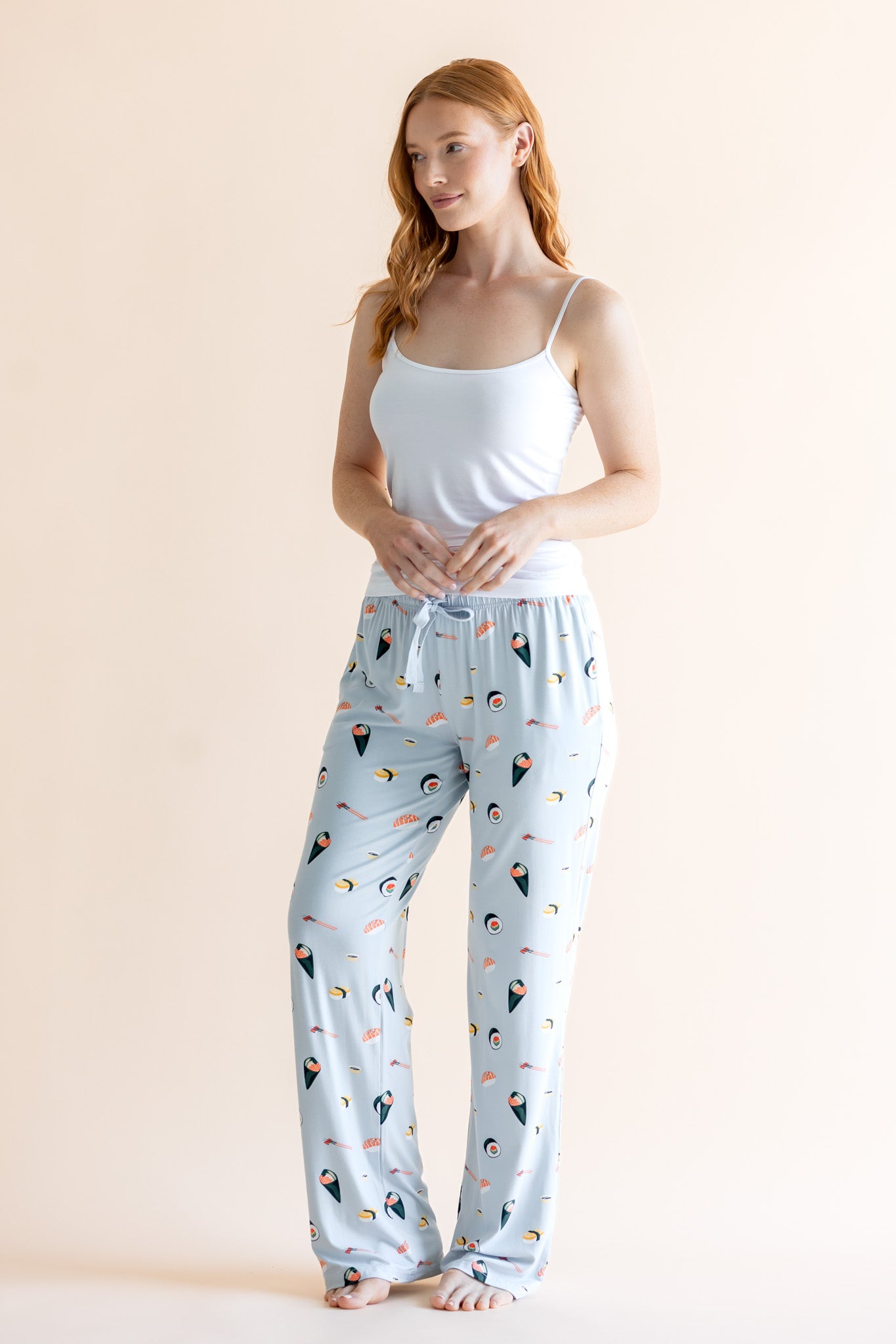 Model wearing blue Women's Lounge Pants with Sushi print under white camisole on a beige background. "::: Model is 5'8"" wearing size M ///
