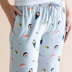Model wearing blue Women's Lounge Pants with pockets in Sushi print under white camisole on a beige background