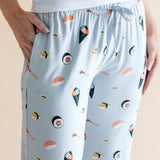 Model wearing blue Women's Lounge Pants with pockets in Sushi print under white camisole on a beige background