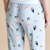 Model showing back side of blue Women's Lounge Pants in Sushi print under white camisole on a beige background