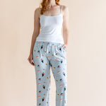 Model in blue Women's Lounge Pants in Sushi print under white camisole on a beige background