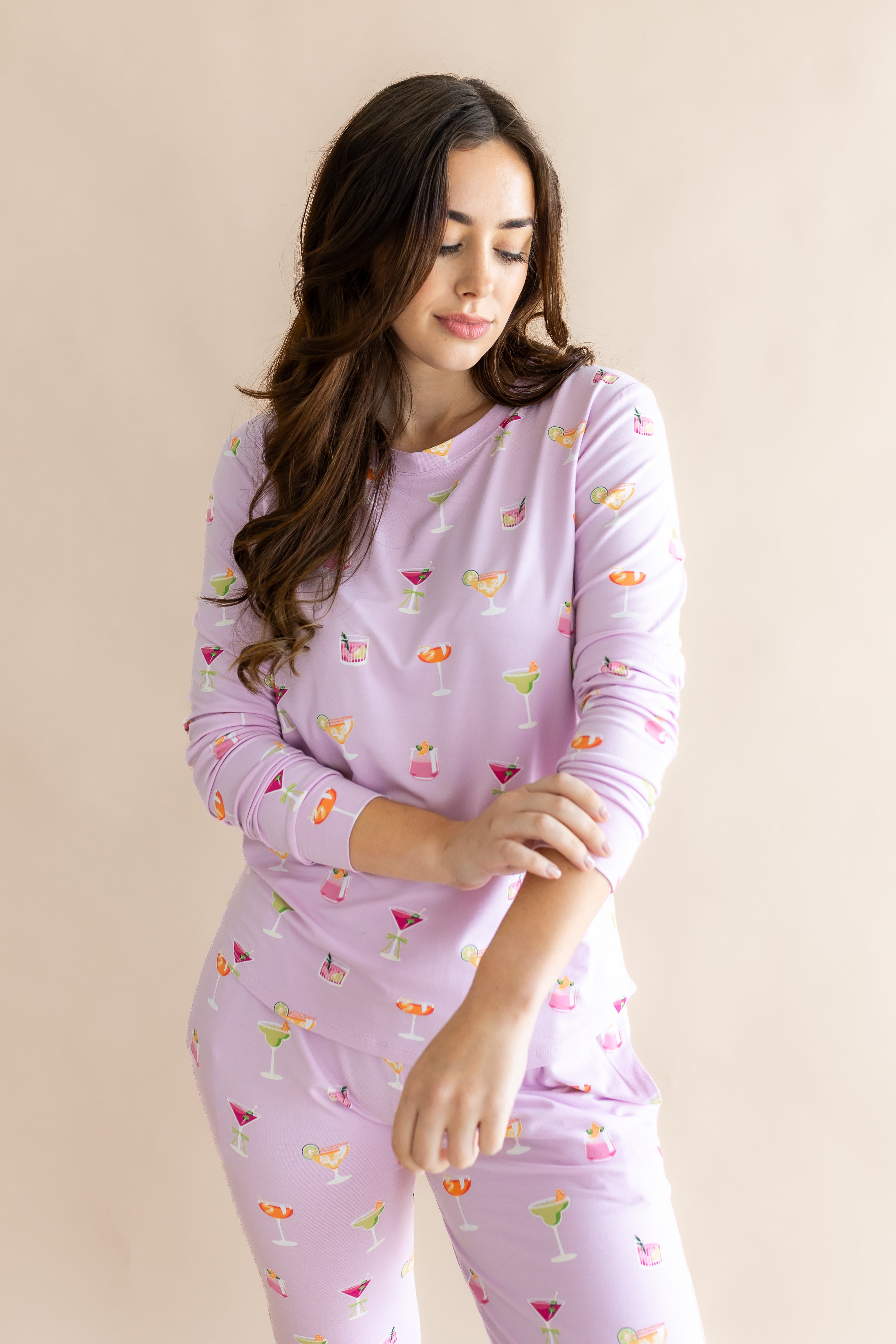 Model looking downwards with sleeves raised up from the Women's Jogger Pajama Set in Cocktail
