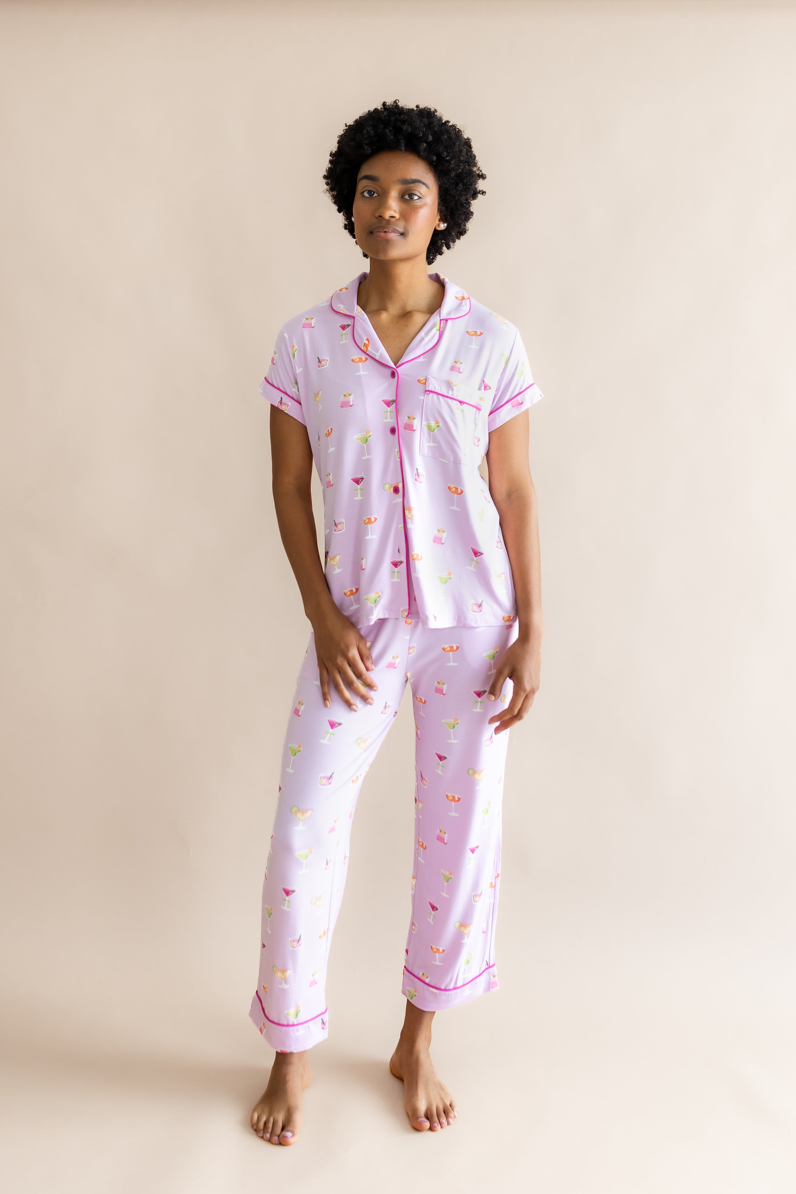 Model standing in front of a beige back ground while wearing the Women's Short Sleeve Cropped Pajama Set in Cocktail
