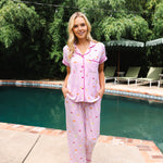 Model standing in front of a pool while wearing the Women's Short Sleeve Cropped Pajama Set in Cocktail