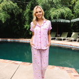 Model standing in front of a pool while wearing the Women's Short Sleeve Cropped Pajama Set in Cocktail