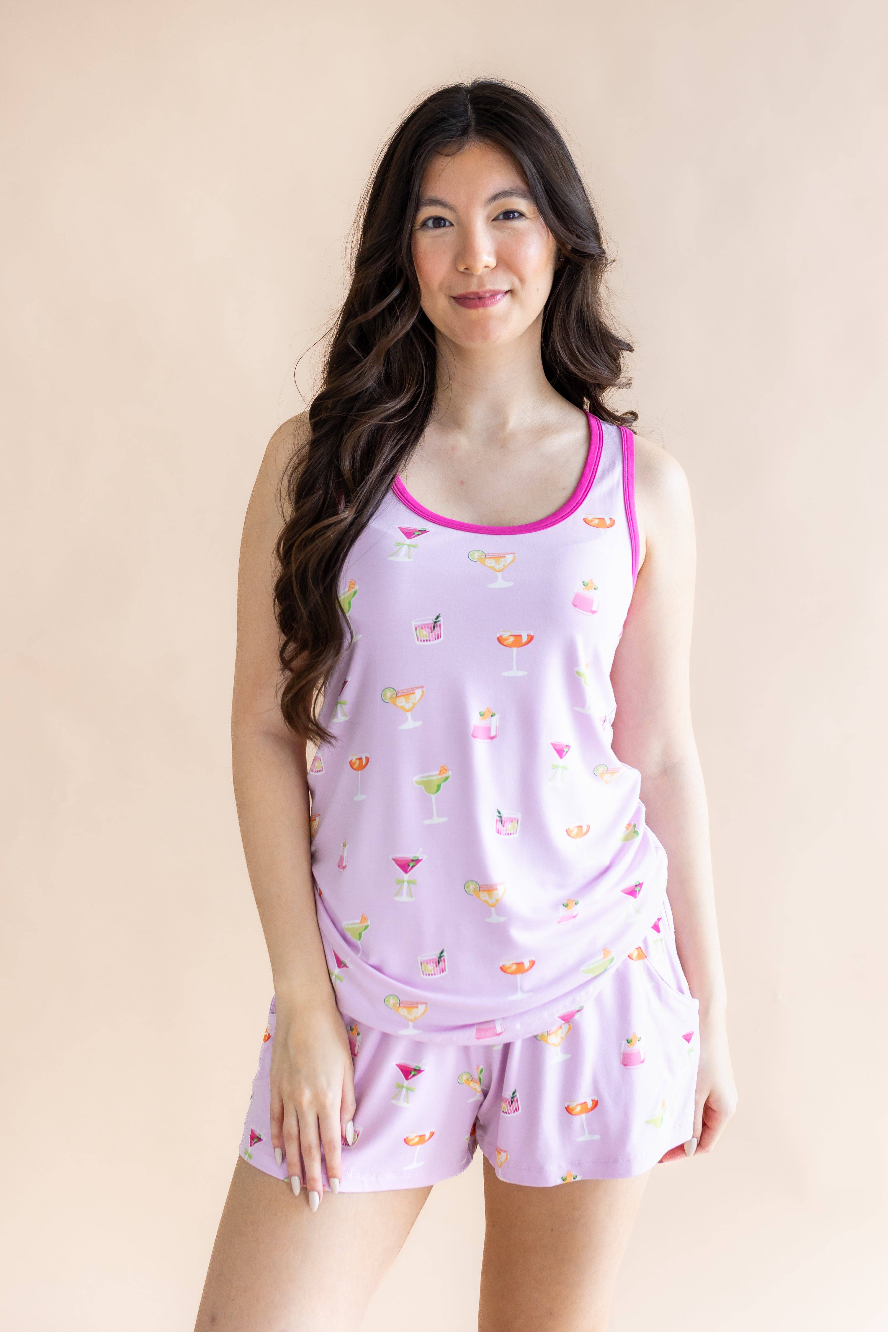 Smiling woman standing in front of a beige back ground while modeling the Women's Tank Set in Cocktail
