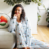 Woman in sushi pajama sitting beside a couch with plants in the background
---1605 3