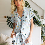 Woman wearing a sushi-themed pajama set in a home setting with plants.
---PJ 2