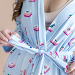Light blue robe with mahjong print worn by a person, on a beige background